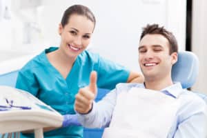 Man in dental chair giving thumbs up